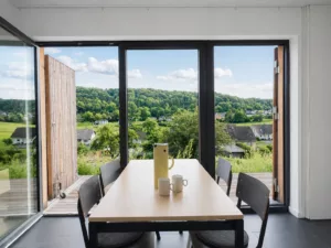 Wohnbereich des eifelhausaufzeit mit großen Fenstern und Blick über die Landschaft