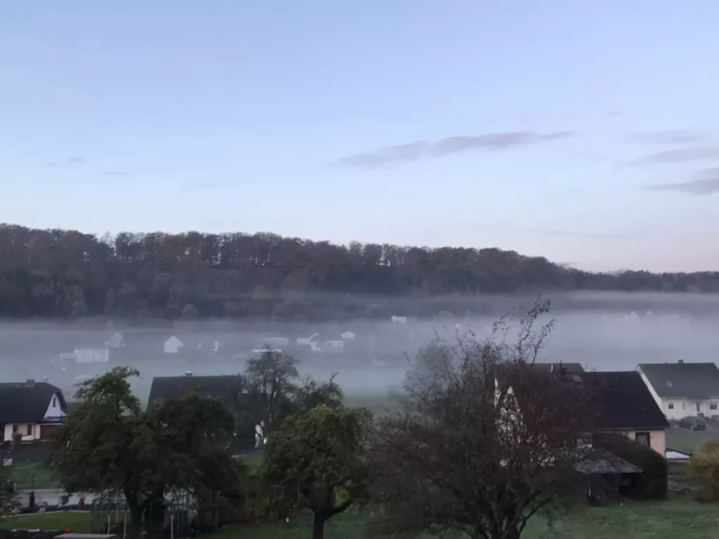 Herbstliche Landschaft der Vulkaneifel mit weiten Hügeln und bewaldeten Höhen.