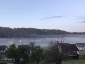 Herbstliche Landschaft der Vulkaneifel mit weiten Hügeln und bewaldeten Höhen.